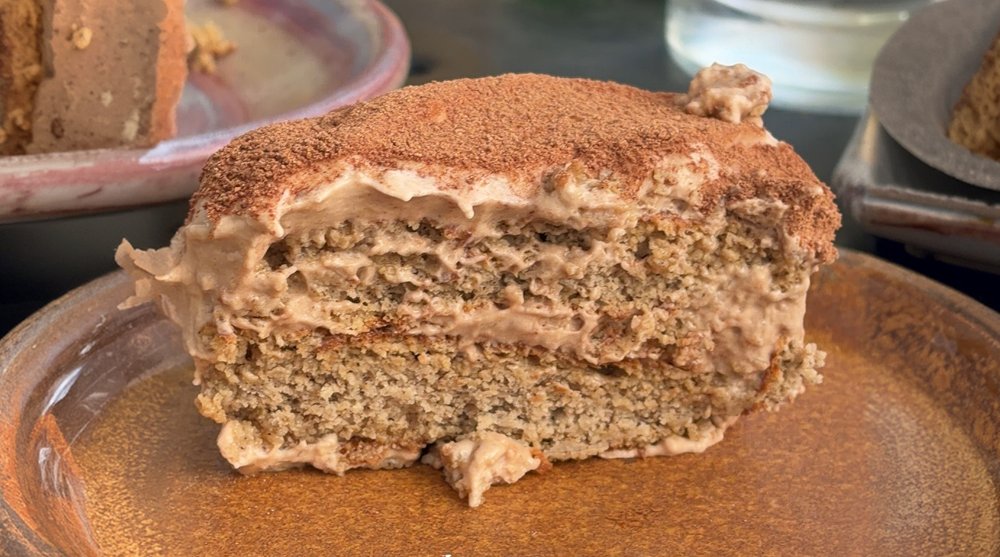 A slice of tiramisu layered with Sol Food pancakes and dusted with cocoa