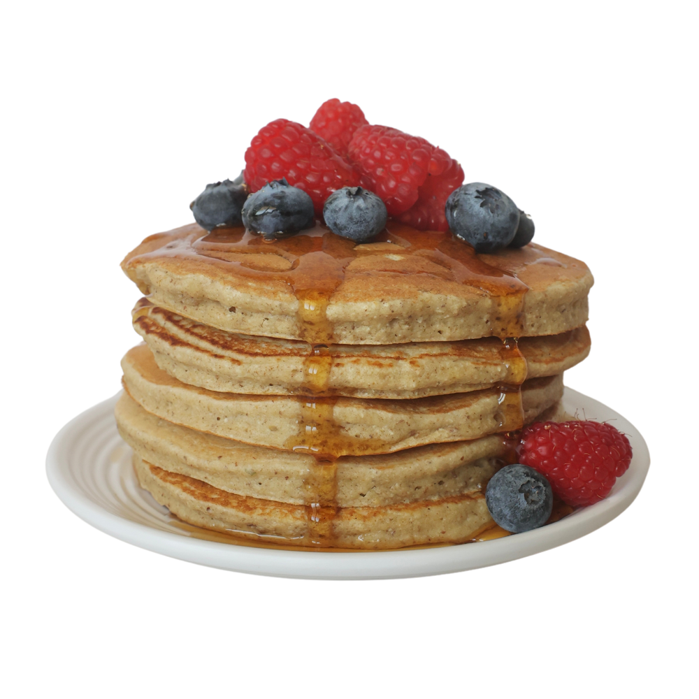 A stack of Sol Food pancakes with raspberries, blueberries and syrup
