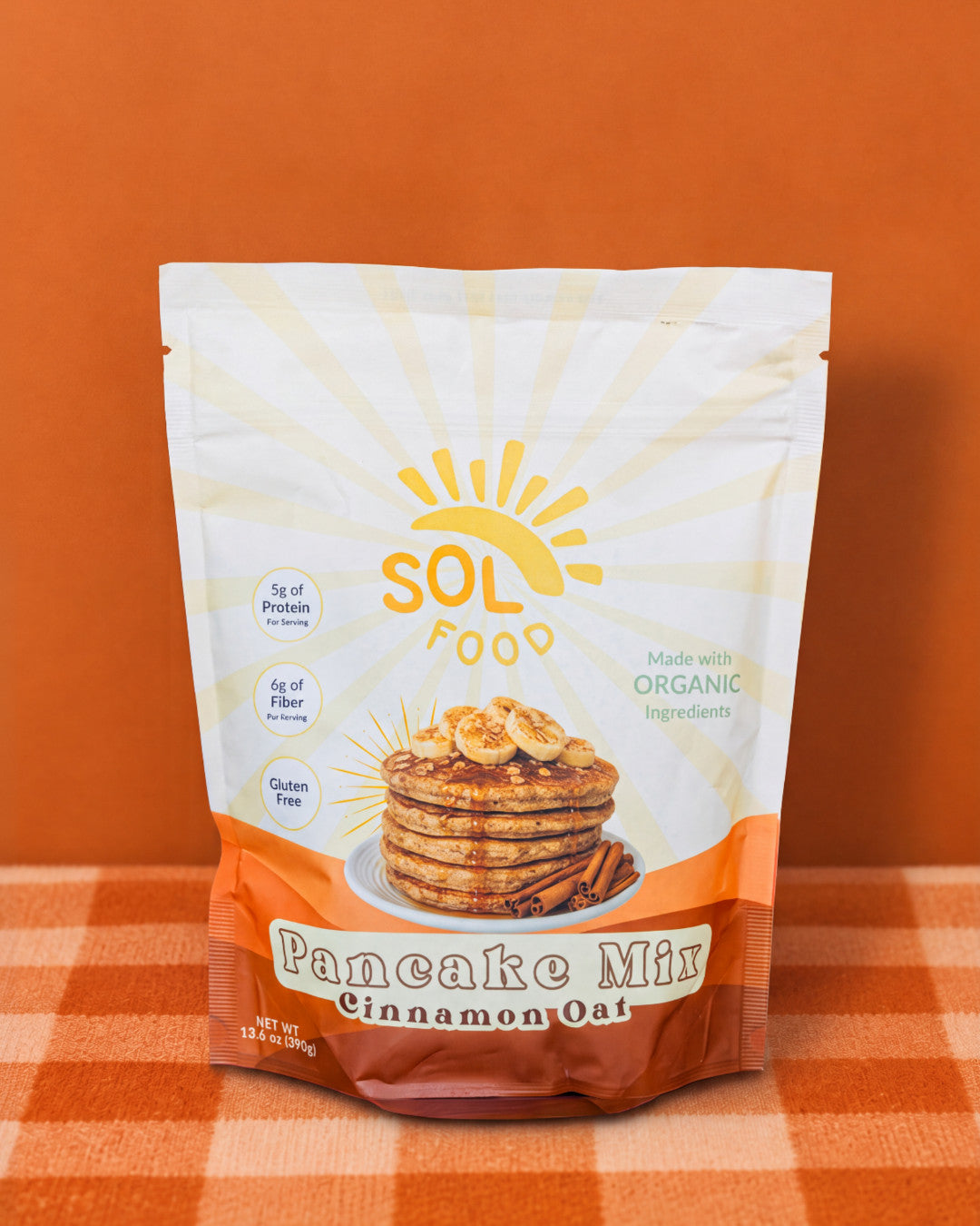 Bag of Sol Food Cinnamon Oat Pancake Mix on a checkered tablecloth