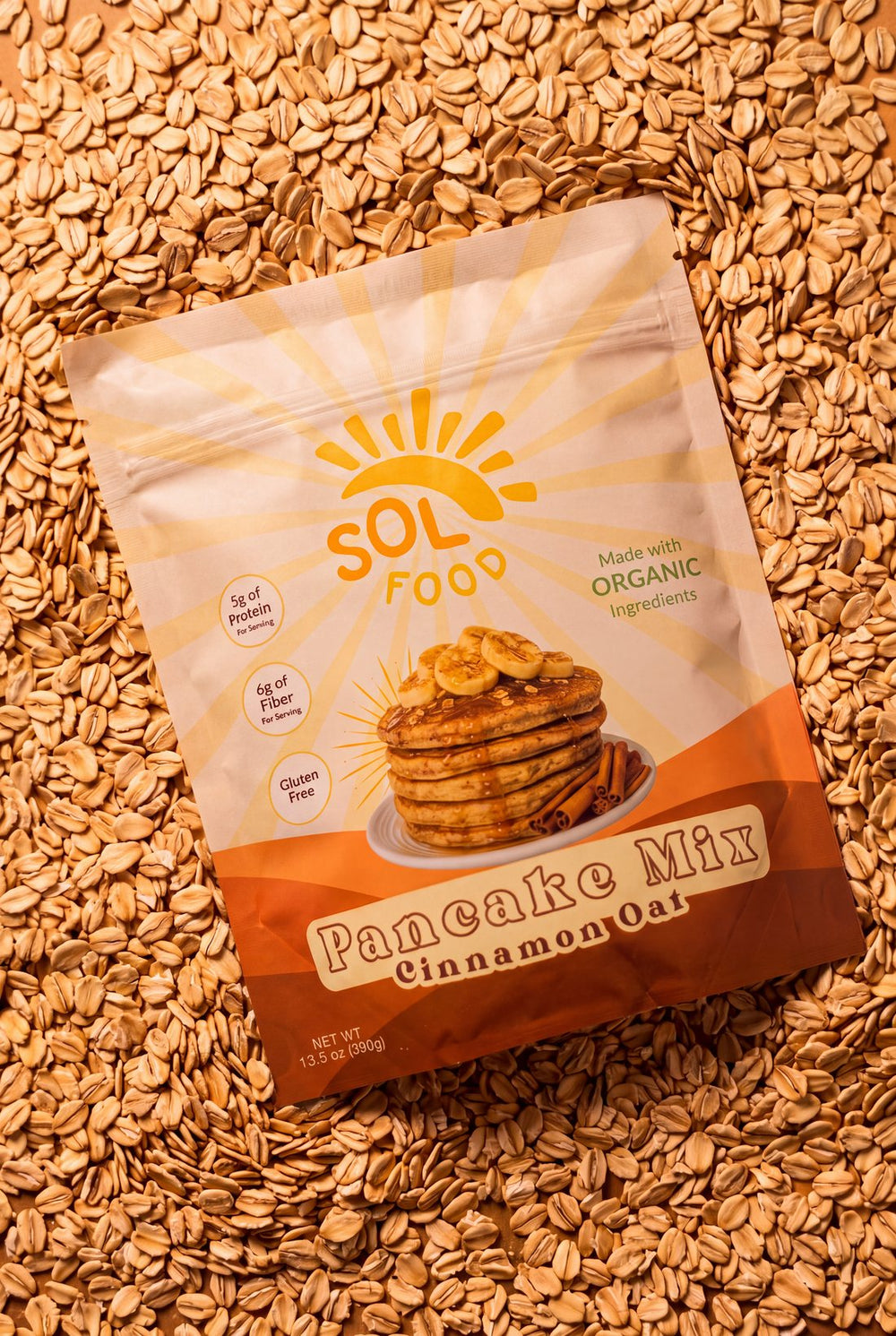 A bag of Sol Food Cinnamon Oat Pancake Mix on a bed of oats